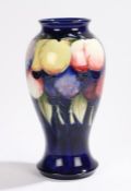 Moorcroft pottery vase, the blue ground with polychrome fruit decoration, 26cm high