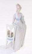 Lladro porcelain figure depicting a lady in evening wear leaning on a chair with small dog to the