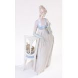 Lladro porcelain figure depicting a lady in evening wear leaning on a chair with small dog to the