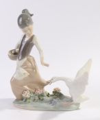 Lladro figure, young girl with a basket of eggs, her dress being pulled by a goose, 20.5cm high