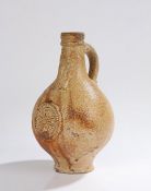 18th Century salt glaze bellarmine jug, with a bearded man to the neck above a star medallion,
