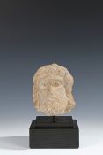 Medieval limestone head, 14th Century, the small size head with long hair and a beard, 13cm high