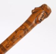 Late 19th Century Folk Art walking stick, the stick carved with raised faces, an etched boxing scene