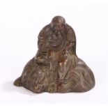 Japanese bronze effect figure, Meiji period, a seated scholar above a Komainu, 65mm diameter