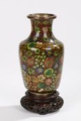 Chinese Cloisonné vase, decorated with colourful flower heads, 16cm high, raised on a carved