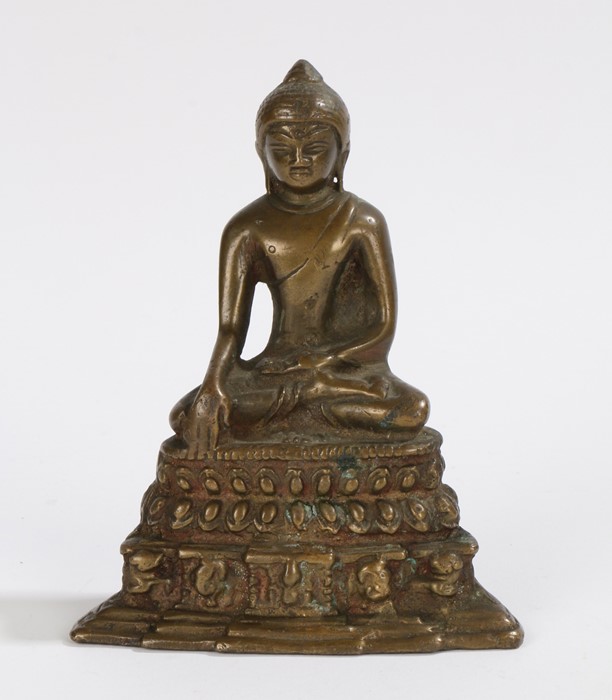 Chinese bronze buddha, seated position above a steeped base, 13.5cm high