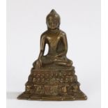 Chinese bronze buddha, seated position above a steeped base, 13.5cm high