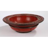 Chinese red lacquer bowl, with a bat and symbol design to the edge of the deep bowl, 30.5cm diameter
