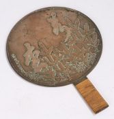Japanese Edo period bronze hand held mirror, decorated with trees and text, 23cm diameter