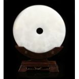 Chinese polished stone disc, of large proportions, the white stone with central hole and tapered