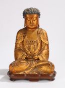 Chinese gilt lacquered wood figure of Buddha, Qing Dynasty, the pointed hair whorls framing a red