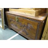 20th Century Chinese camphor chest, the front with carved figures depicting figures, foliage, and