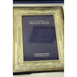 Elizabeth II silver photo frame, with scroll decorated border, housed in original box