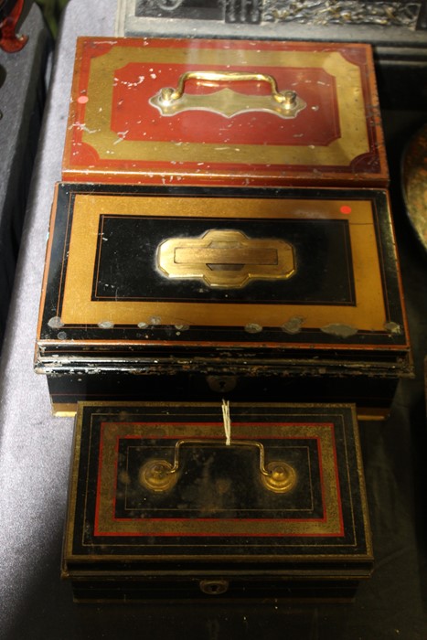 Three late Victorian cash tins, with ebonised, red and gilt decoration, the largest 26cm wide (3)