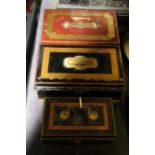Three late Victorian cash tins, with ebonised, red and gilt decoration, the largest 26cm wide (3)