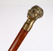 Brass and malacca walking stick, surmounted with a bust of a smiling man, 93cm high