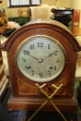 Edwardian walnut and boxwood strung mantel clock, with arched pediment, the silvered dial with