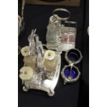 Two plated cruet frames containing various glass bottles, pair of plated salts with blue glass