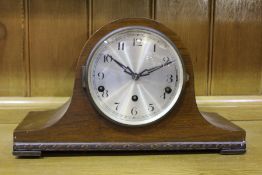 Edwardian walnut mantel clock, the arched case and silvered dial with Arabic numerals, 38cm wide