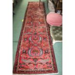 Eastern runner, the red ground with foliate decorations, surrounded by a geometric border,