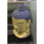 Tibetan bronze deity head, with painted blue decoration, 14cm high