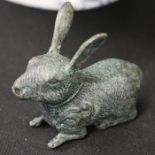 Bronze effect brass rabbit, depicted in a laying position with ears raised, 9cm long