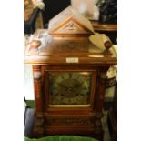 Edwardian walnut and brass mounted mantel clock, the triangular mask decorated pediment flanked by