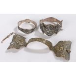 Three Middle Eastern silver and white metal bangles, with scroll decoration (3)