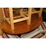 20th Century mahogany breakfast table, the oval top above a turned column, raised on four saber legs