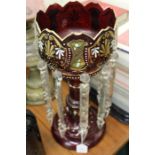 Victorian lustre, the ruby glass body with white and gilt foliate decoration and clear glass hanging