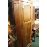 Arts and Crafts oak wardrobe, the paneled door opening to reveal a single shelf and a mirror to