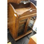 Edwardian oak smokers cabinet, the twin glazed doors opening to reveal a Royal Doulton tobacco jar