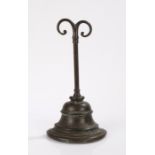 19th Century bronze door stop, the scrolled top above a cylindrical central stem and stepped