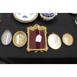 Ormolu picture frame with foliate swag and ribbon pediment, four oval miniature frames (5)