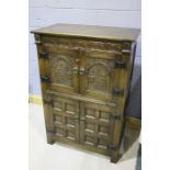 17th Century style oak drinks cabinet, the carved frieze above two paneled doors, with carved