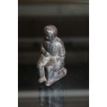 Victorian cast metal figure depicting a young child on a chamber pot
