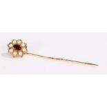 Gold coloured metal stick pin, the head set with a central garnet surrounded by pearls, 3.6g