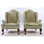 Howard & Sons, an impressive pair of armchairs, the high arched back above a deep seat and swept