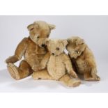 Three early 20th Century teddy bears, each golden with pad feet and paws, the longest 57cm long, (