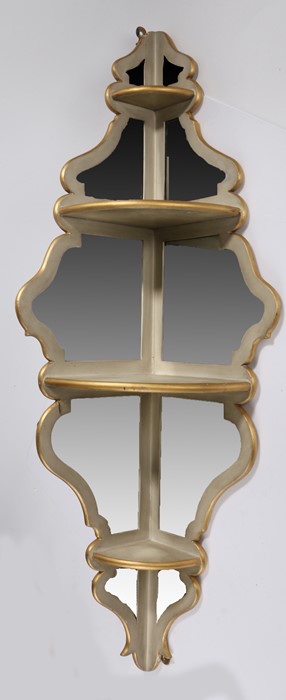 Italian corner shelf, in cream and gilt with shaped mirror plates to the back, 106cm high