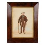 19th Century naïve picture of a gentleman standing with a grey hat and cane, housed within a