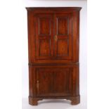 George III oak and elm standing corner cabinet, the concave cornice above a pair of panel doors