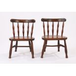 Pair of oak childs/dolls chairs, with an arched top rail above spindle backs and a solid seats