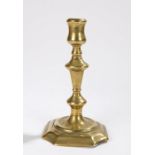 18th Century brass candlestick, the socket above the baluster stem and wide base, 18.5cm high