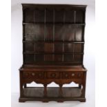 18th Century oak dresser and rack, the rack with an undulating pediment above three shelves, the
