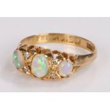 Gold and opal set ring, with three cabochon opals and diamonds to either side of the central opal,