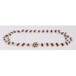 Pearl and garnet necklace, the two strands united by the 9 carat gold flower head clasp, 56cm long