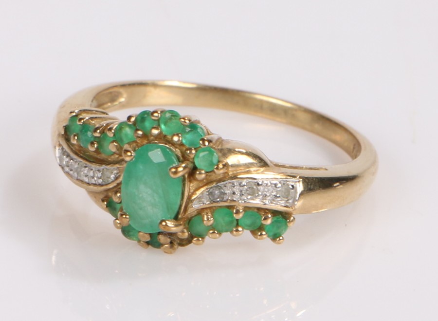 9 carat gold emerald and diamond set ring, with a central emerald flanked by further emeralds and