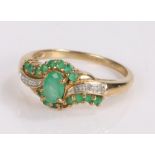 9 carat gold emerald and diamond set ring, with a central emerald flanked by further emeralds and