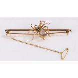 9 carat gold insect brooch, as a spider with a pink gemstone and emerald to the back, 75mm long, 8.5